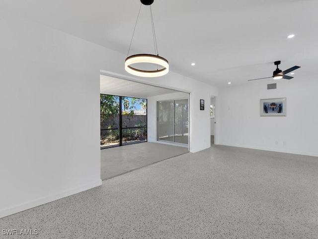 unfurnished room featuring visible vents, baseboards, recessed lighting, speckled floor, and a ceiling fan