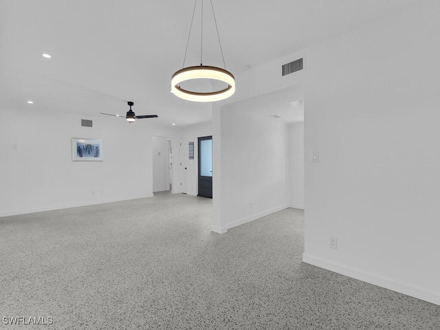 empty room with baseboards, recessed lighting, speckled floor, and visible vents