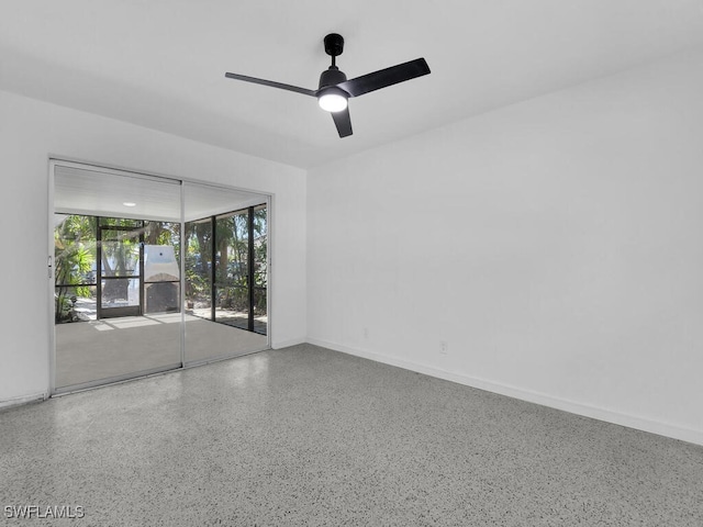 unfurnished room featuring a ceiling fan, baseboards, and speckled floor