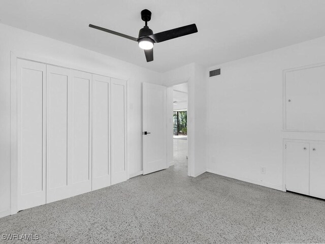 unfurnished bedroom with visible vents, baseboards, speckled floor, and ceiling fan