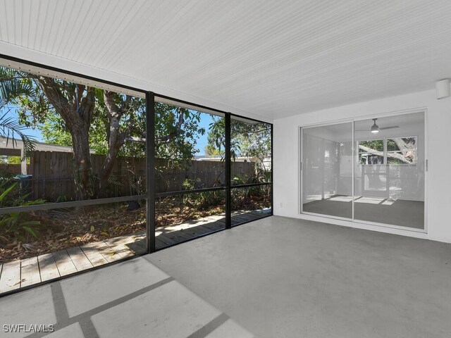unfurnished sunroom with ceiling fan and a healthy amount of sunlight