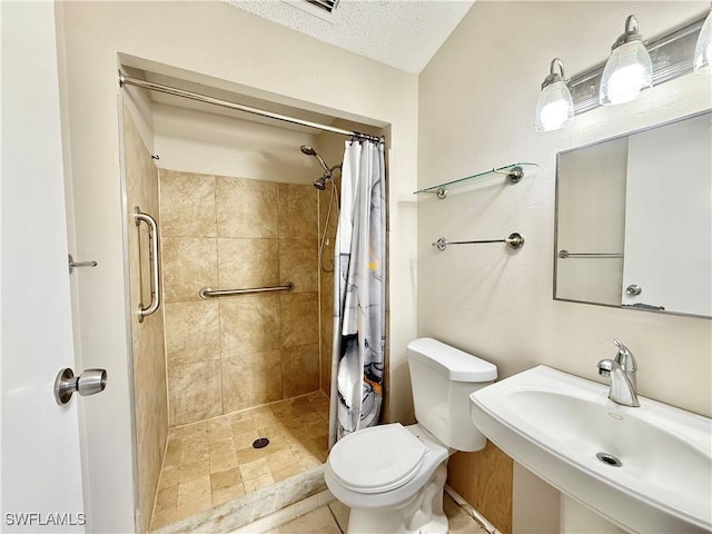 full bathroom featuring a sink, a textured ceiling, a stall shower, and toilet