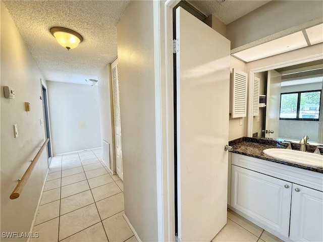 bathroom featuring a textured ceiling, tile patterned flooring, and vanity