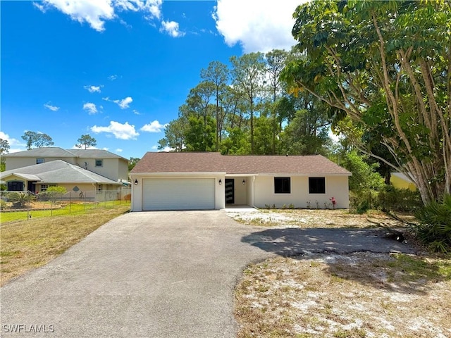 single story home with fence, an attached garage, stucco siding, and aphalt driveway