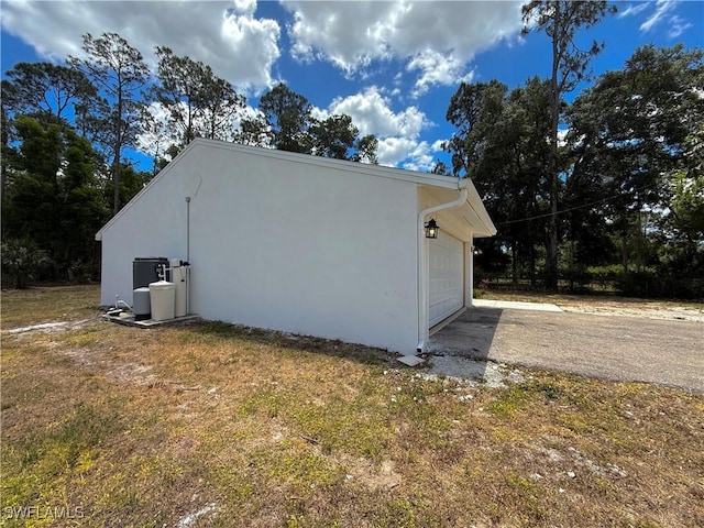 view of home's exterior with stucco siding, driveway, and a garage