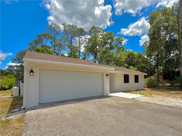 ranch-style house featuring stucco siding and aphalt driveway