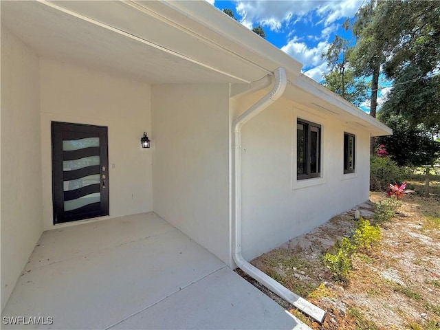 doorway to property with stucco siding