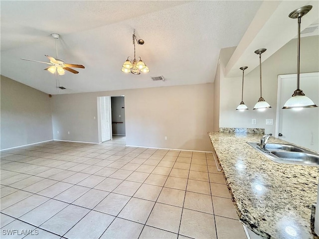 interior space featuring a sink, high vaulted ceiling, ceiling fan with notable chandelier, light tile patterned floors, and visible vents