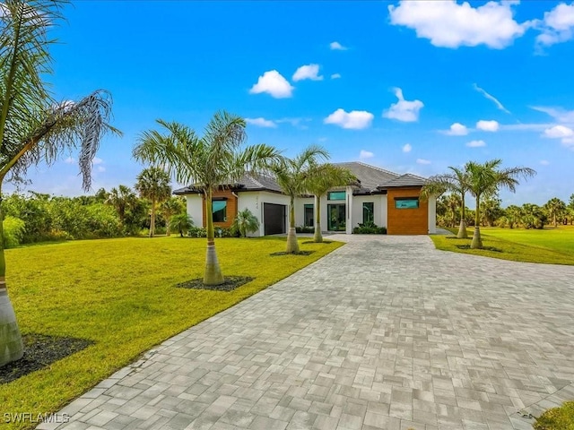 view of front of house featuring a garage, decorative driveway, and a front yard