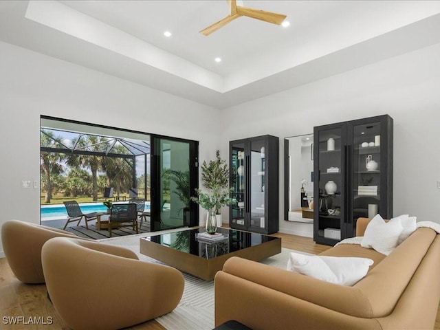 living area featuring ceiling fan, a sunroom, wood finished floors, a high ceiling, and recessed lighting