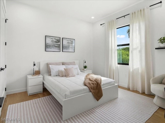 bedroom with light wood-style floors, baseboards, and recessed lighting