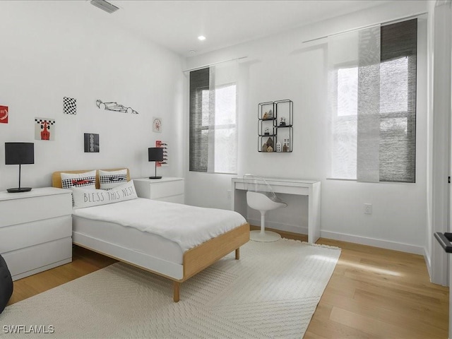 bedroom with recessed lighting, baseboards, visible vents, and wood finished floors