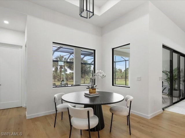 dining area with baseboards and light wood-style flooring