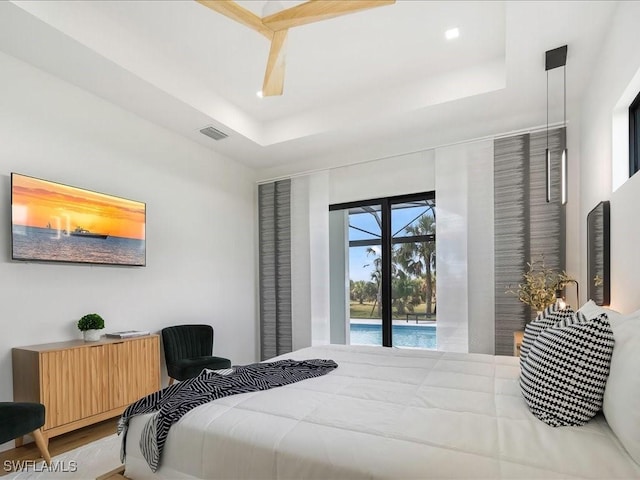 bedroom with visible vents, recessed lighting, a tray ceiling, and access to exterior