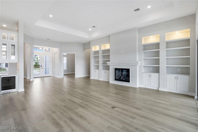 unfurnished living room featuring light wood-style floors, baseboards, a glass covered fireplace, and recessed lighting