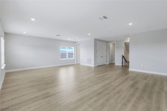 unfurnished living room with light wood-type flooring, visible vents, baseboards, and recessed lighting