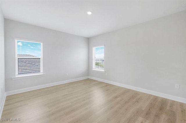 empty room featuring light wood-style floors, baseboards, and recessed lighting
