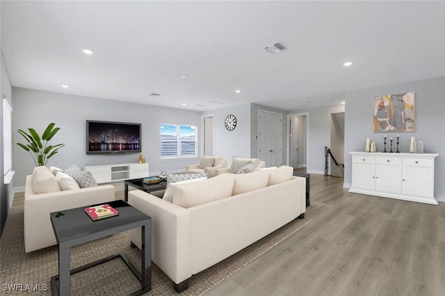 living room featuring visible vents, light wood-style flooring, baseboards, and recessed lighting