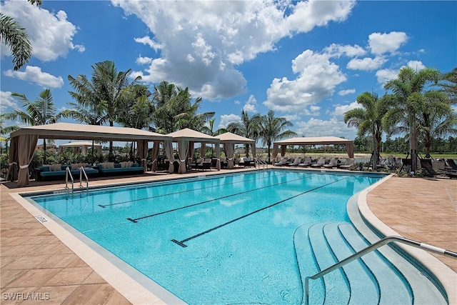 community pool with a gazebo and outdoor lounge area