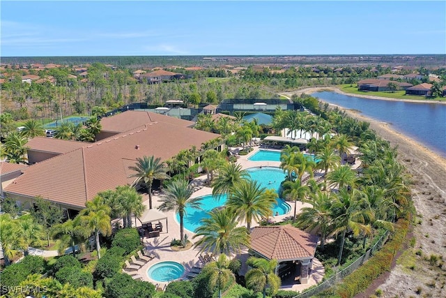 drone / aerial view of a pool area and a large body of water