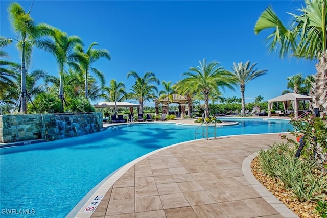 community pool with a gazebo and a patio area