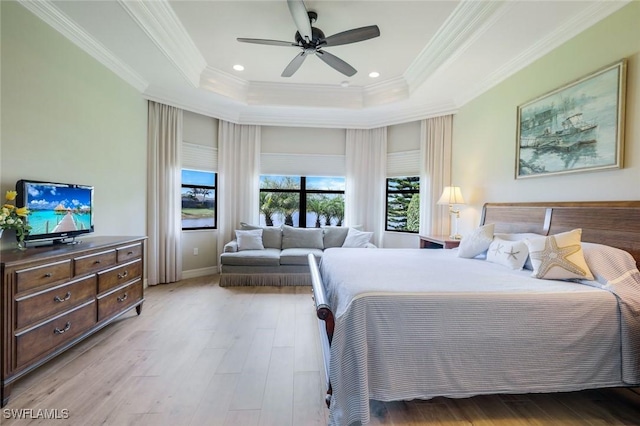 bedroom with a raised ceiling, crown molding, wood finished floors, baseboards, and ceiling fan