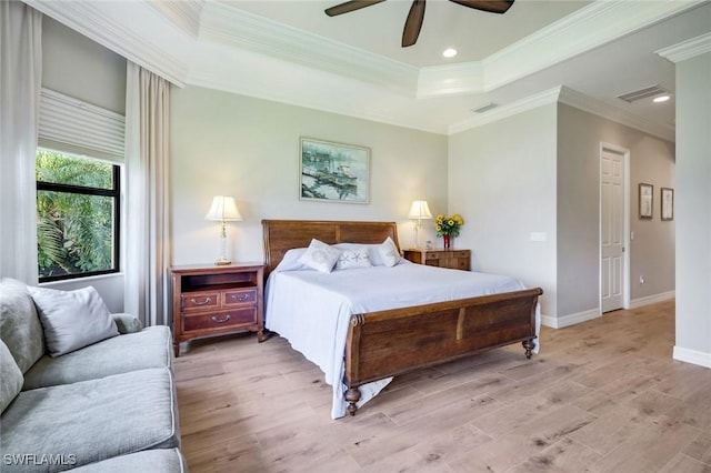 bedroom featuring light wood-style floors, a raised ceiling, baseboards, recessed lighting, and crown molding