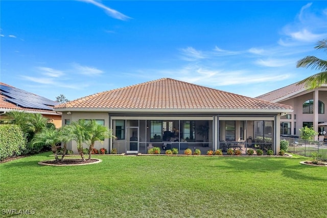 rear view of house featuring a tiled roof, a sunroom, and stucco siding