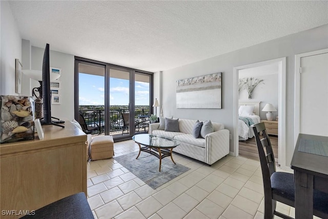 180 Seaview Ct Unit 814, Marco Island, FL 34145 - living room with a textured ceiling, light tile patterned floors, and a wall of windows