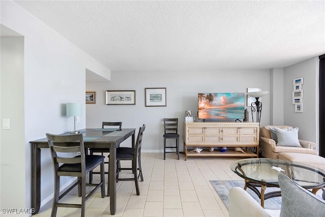 180 Seaview Ct Unit 814, Marco Island, FL 34145 - living area with a textured ceiling, baseboards, and light tile patterned floors