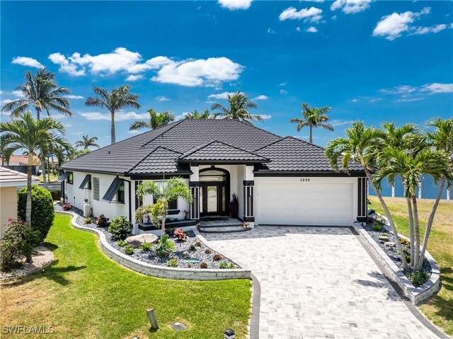 1255 Eider Ct, Punta Gorda, FL 33950 - mediterranean / spanish-style house featuring an attached garage, a front lawn, and stucco siding