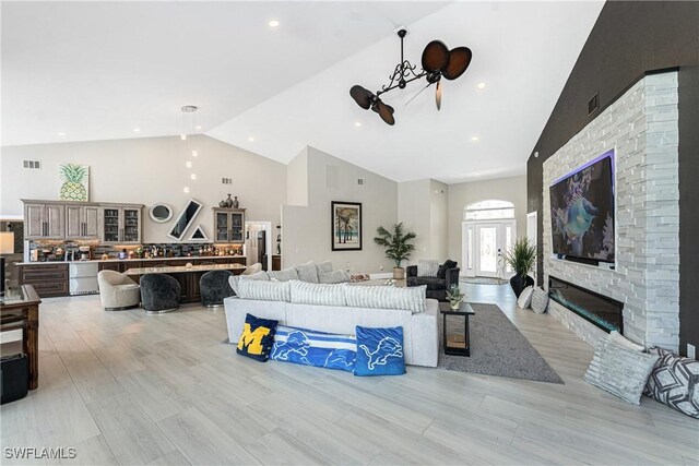 1255 Eider Ct, Punta Gorda, FL 33950 - living room with high vaulted ceiling, light wood-type flooring, a stone fireplace, and recessed lighting