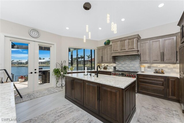 1255 Eider Ct, Punta Gorda, FL 33950 - kitchen with french doors, tasteful backsplash, a sink, hanging light fixtures, and recessed lighting