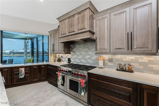 1255 Eider Ct, Punta Gorda, FL 33950 - kitchen featuring double oven range, decorative backsplash, light wood finished floors, and light stone counters