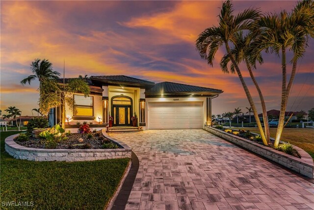 1255 Eider Ct, Punta Gorda, FL 33950 - mediterranean / spanish-style home featuring a garage, decorative driveway, and stucco siding