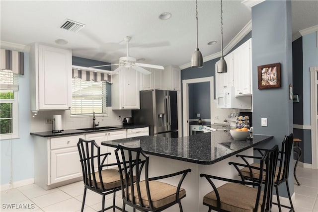 4752 Maupiti Way, Naples, FL 34119 - kitchen featuring stainless steel fridge, a sink, white microwave, light tile patterned floors, and a peninsula