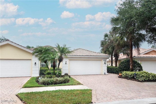 4752 Maupiti Way, Naples, FL 34119 - ranch-style house with stucco siding, a tiled roof, a garage, and decorative driveway