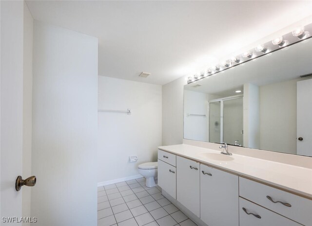 full bath featuring a stall shower, tile patterned floors, toilet, vanity, and baseboards