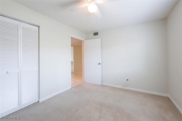 unfurnished bedroom featuring carpet flooring, a closet, baseboards, and ceiling fan