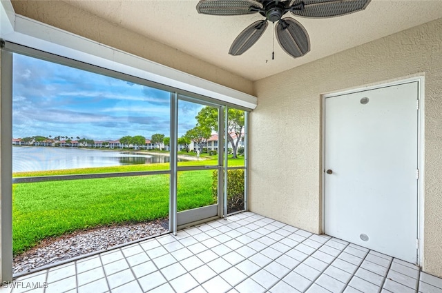 unfurnished sunroom with a water view and a ceiling fan