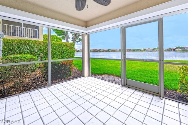 unfurnished sunroom featuring a water view and ceiling fan