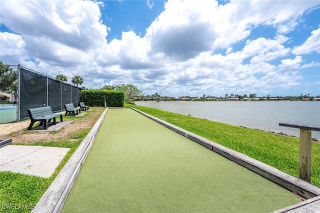 view of community featuring a game area, a water view, and fence