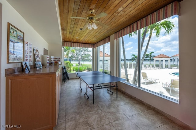 playroom featuring wood ceiling, a ceiling fan, baseboards, and light tile patterned floors