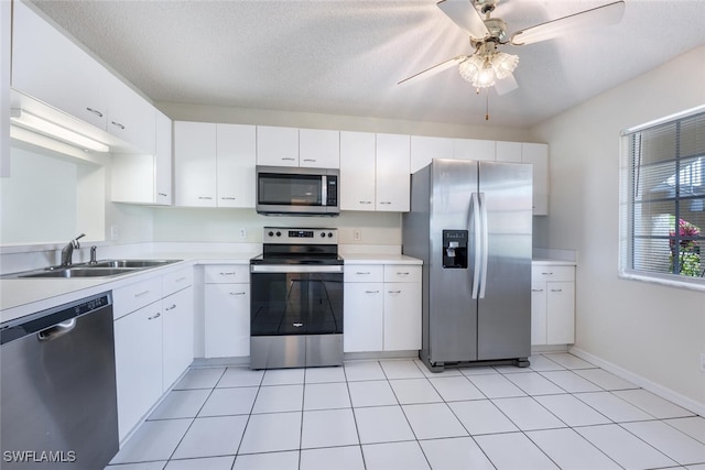 kitchen featuring stainless steel appliances, a sink, light countertops, a ceiling fan, and white cabinetry