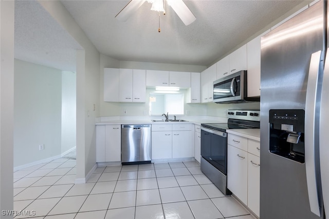 kitchen featuring stainless steel appliances, a sink, light countertops, a ceiling fan, and white cabinets