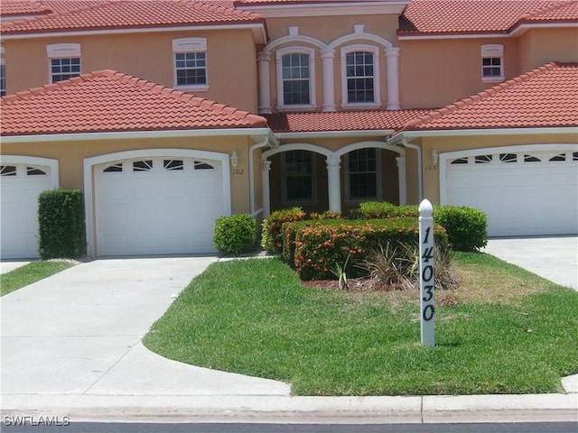 mediterranean / spanish home featuring concrete driveway, stucco siding, and a garage
