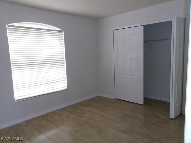 unfurnished bedroom featuring baseboards and a closet
