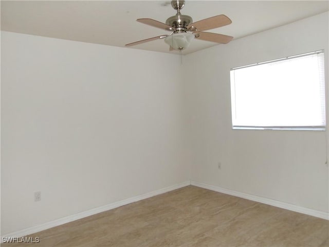 spare room featuring baseboards and a ceiling fan