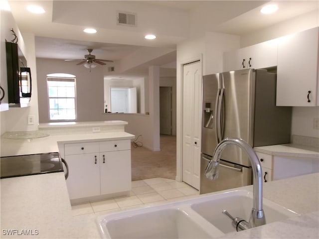 kitchen with a sink, stainless steel refrigerator with ice dispenser, recessed lighting, black microwave, and light countertops