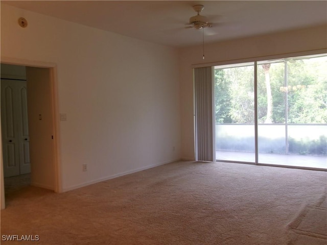 empty room featuring ceiling fan, light colored carpet, and baseboards
